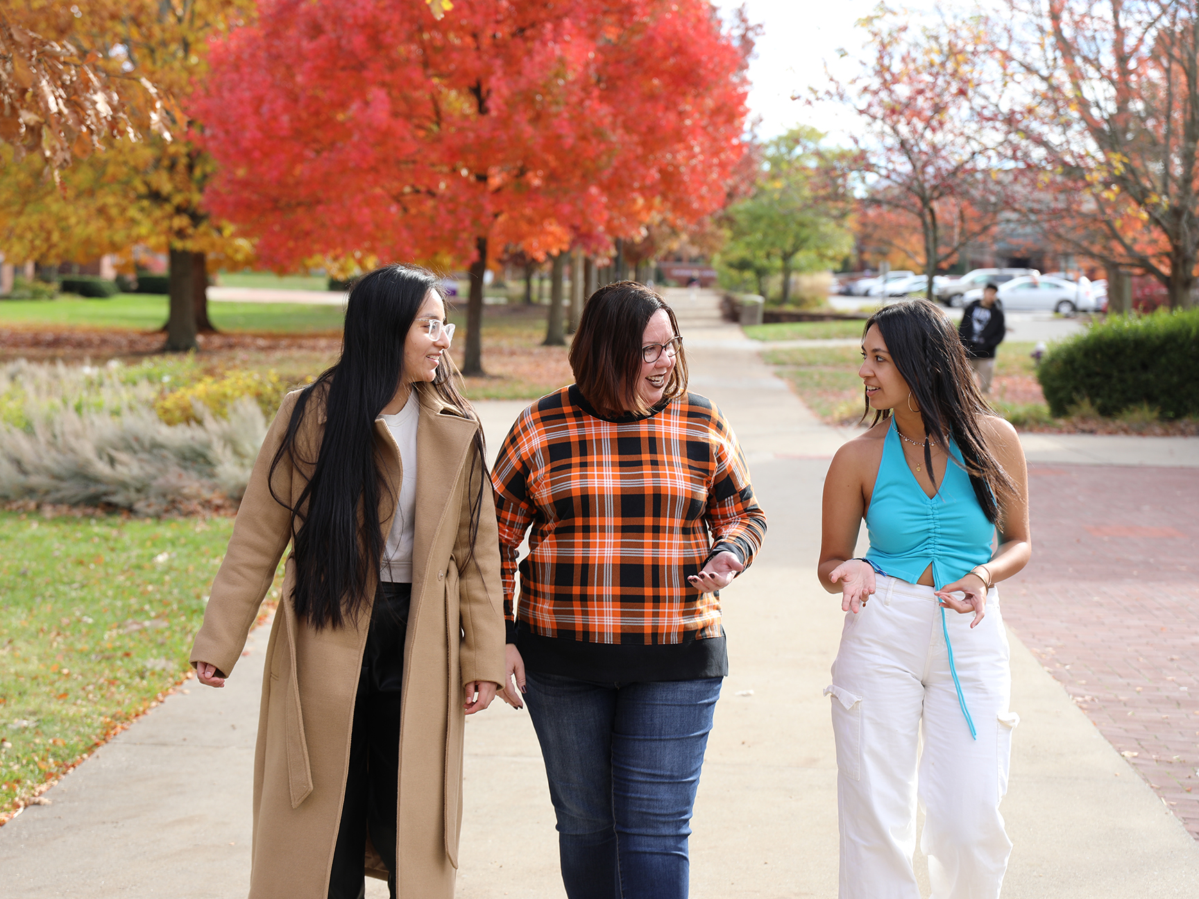 A staff member walking with students on campus