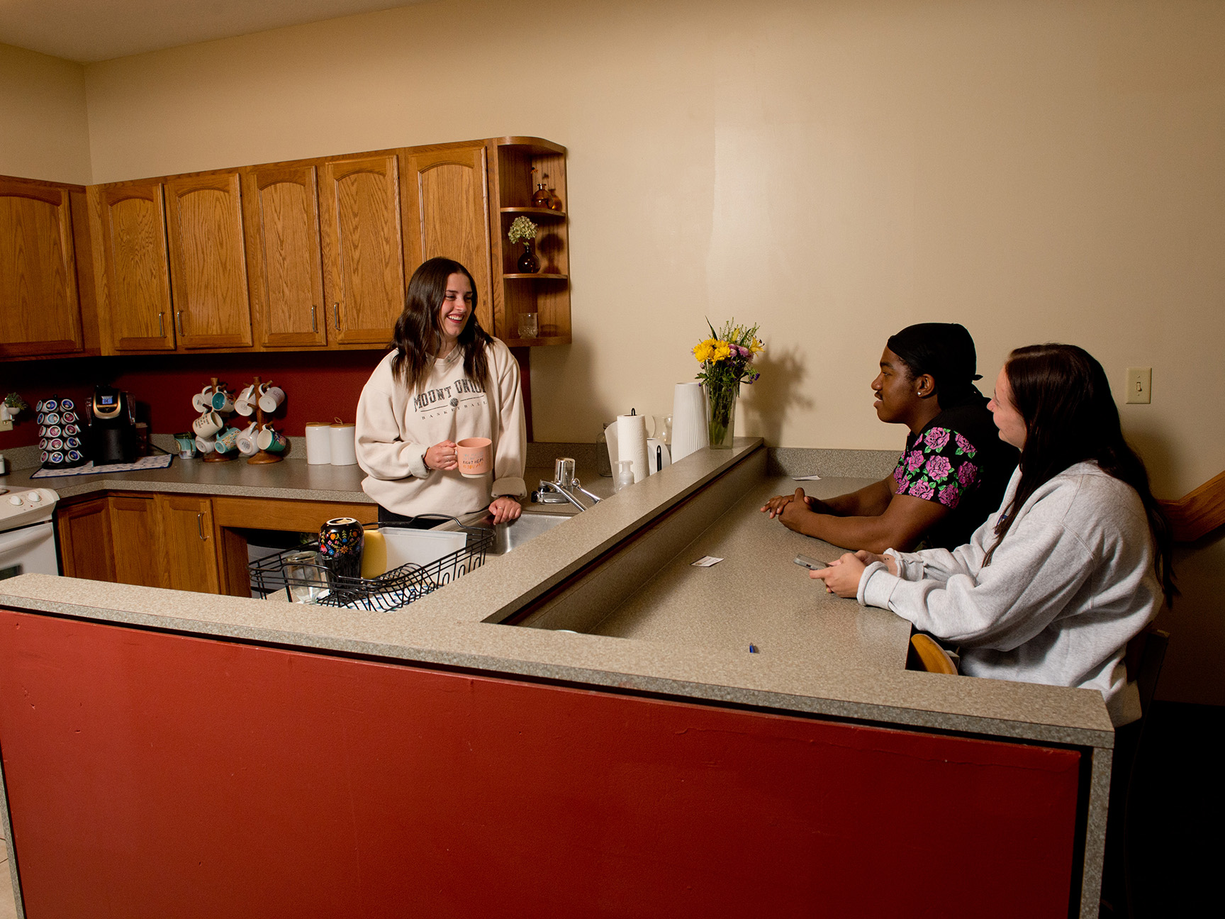 Students hanging out in the kitchen of a townhouse