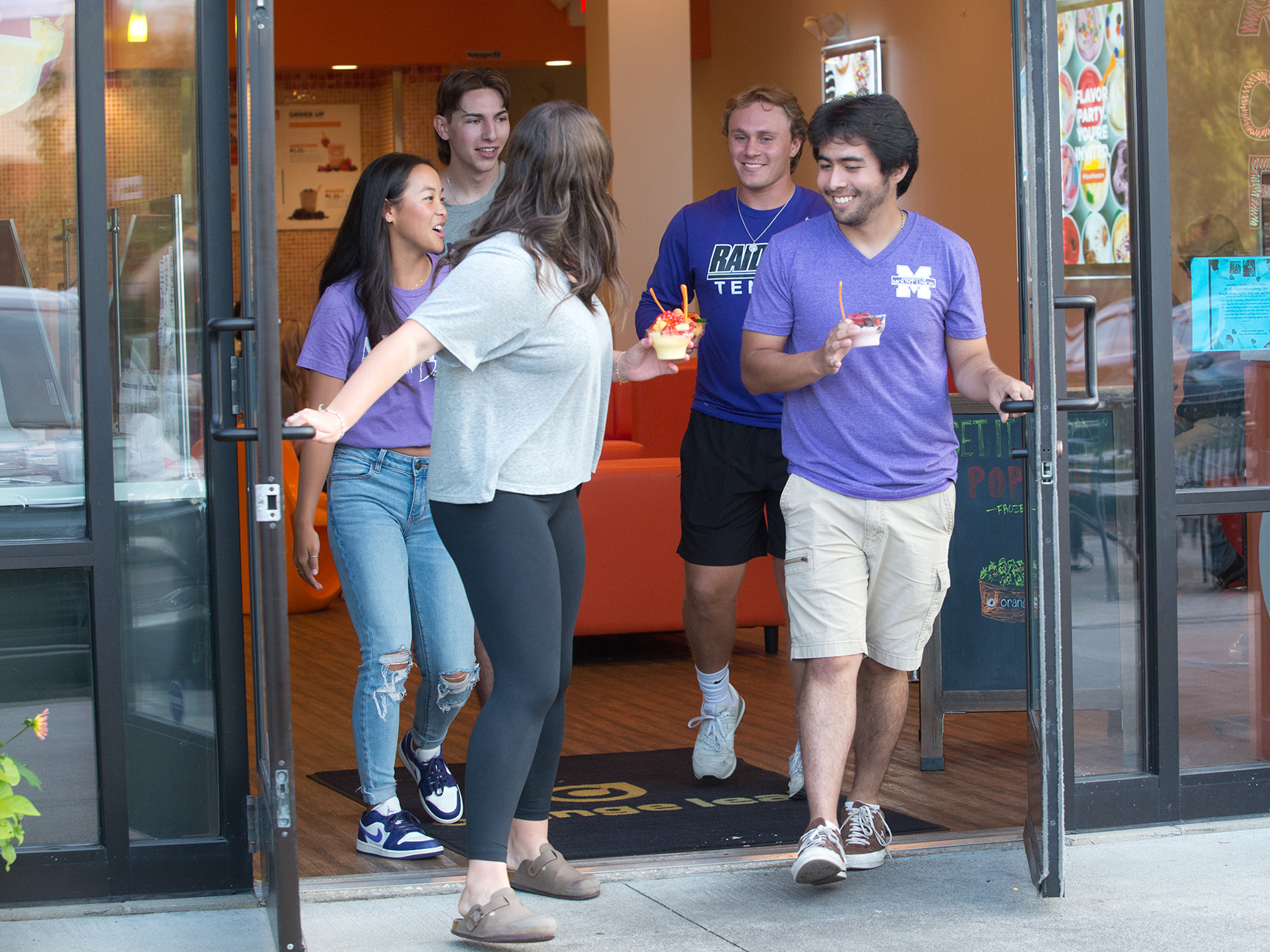 Students leaving a local eatery with frozen yogurt