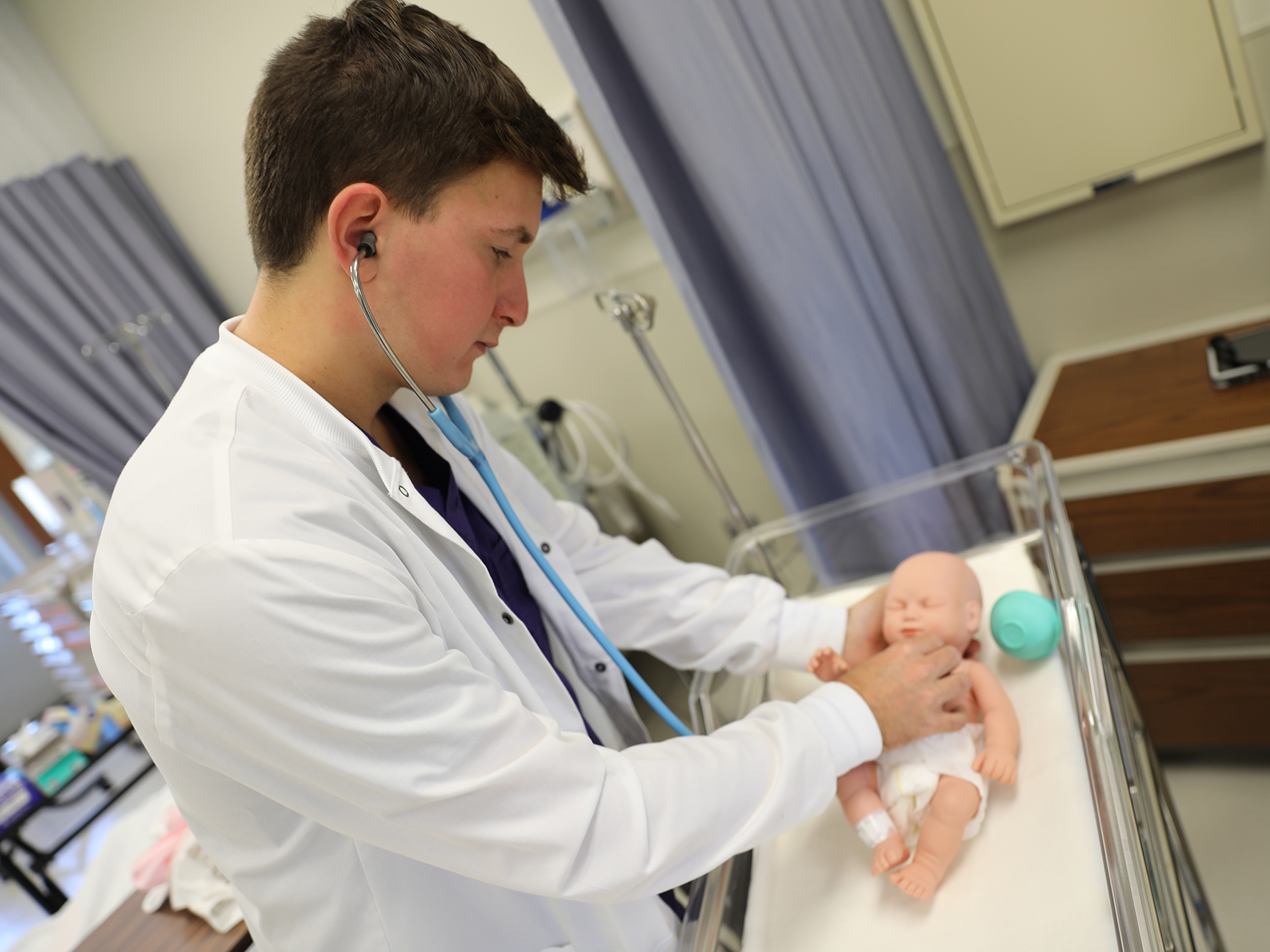 A student utilizing a SIM baby in the nursing lab