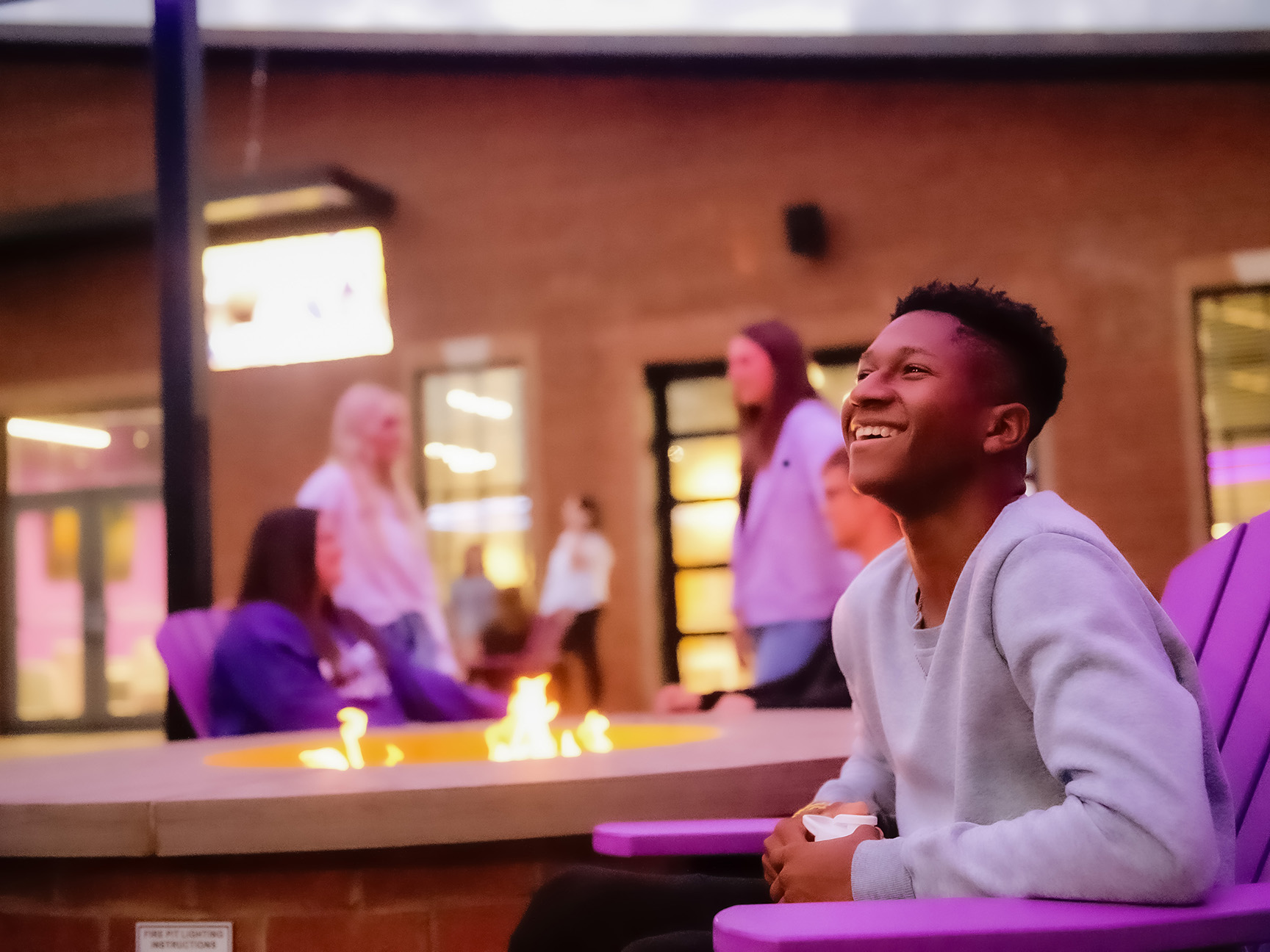 Students enjoying the fire pits on the Campus Grounds patio