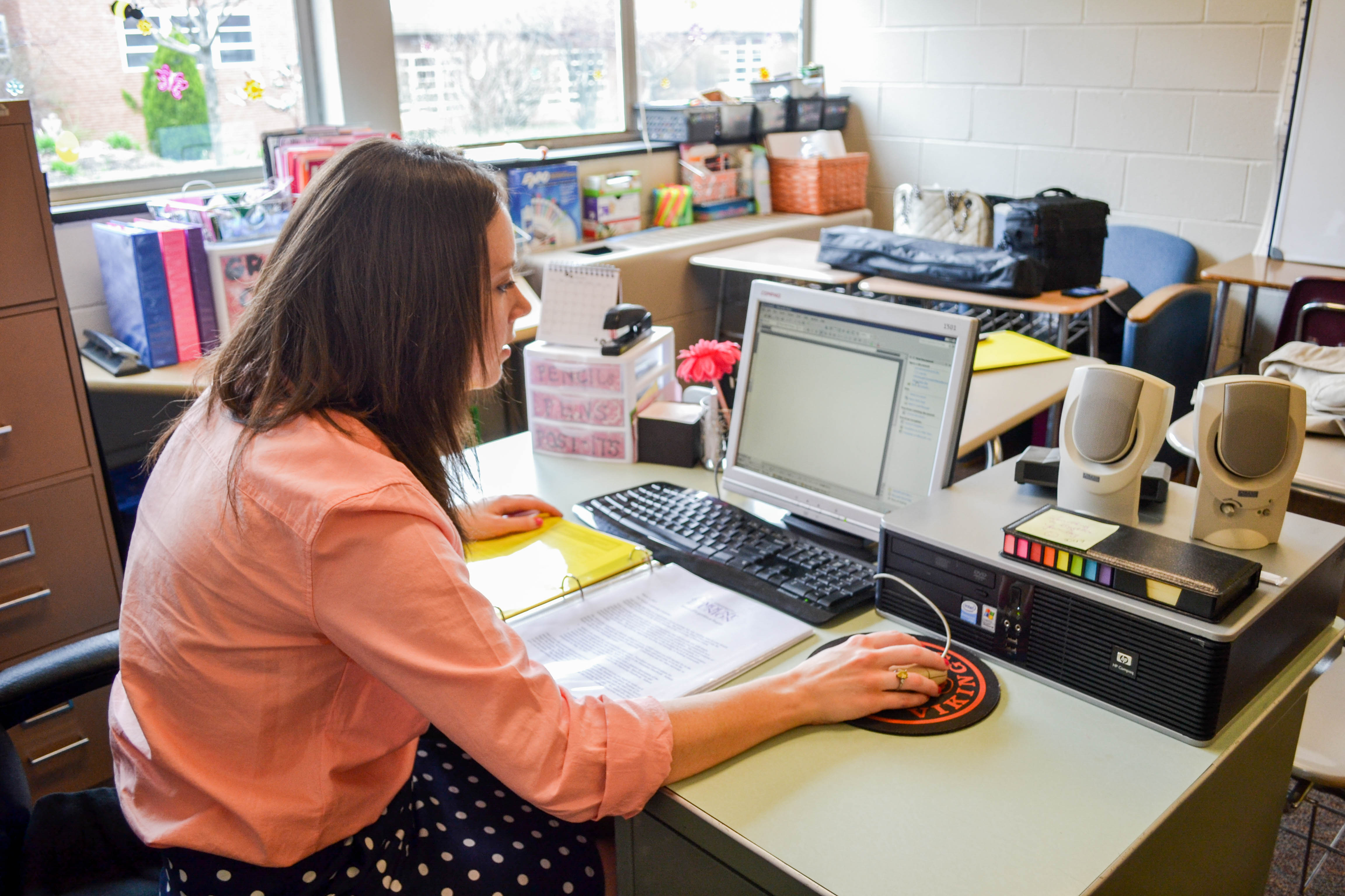 teacher working in classroom on computer