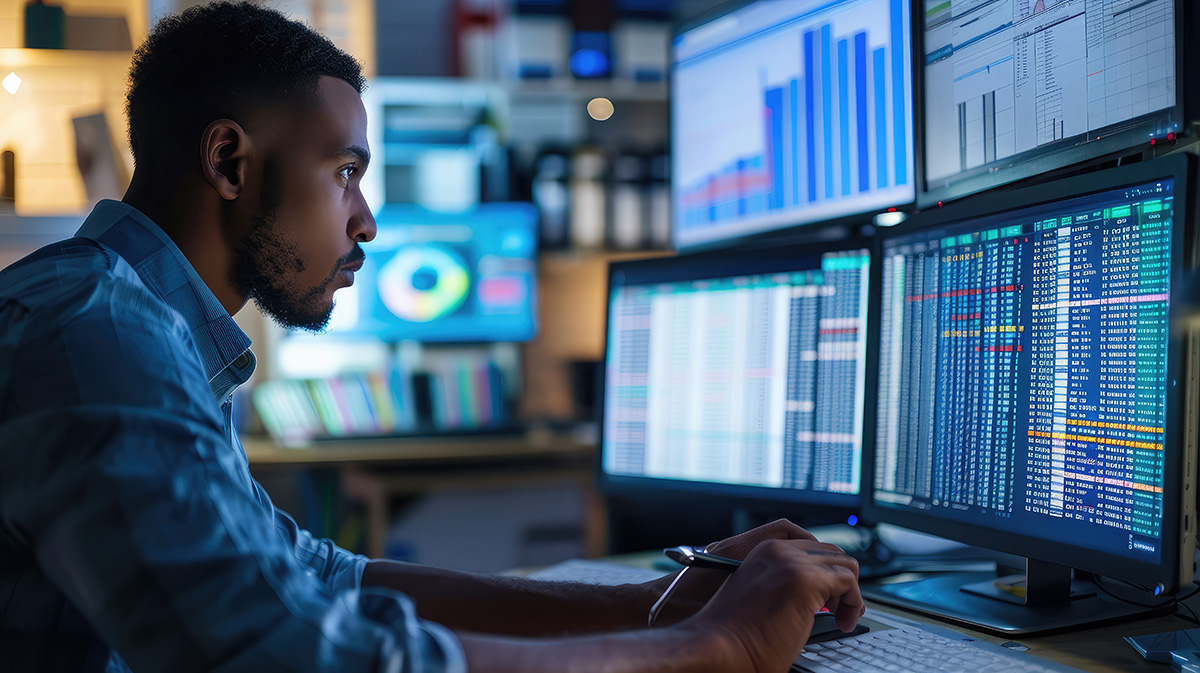 cybersecurity professional working in front of computer monitors.  