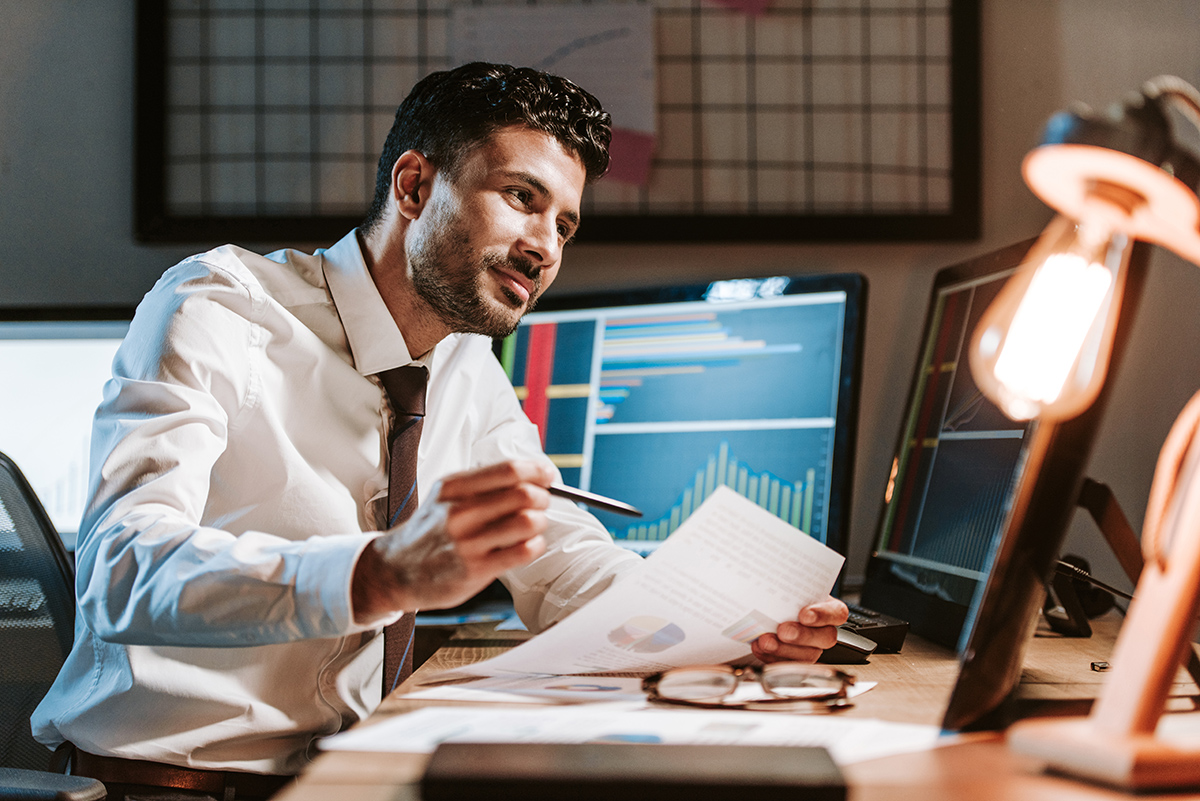 finance professional working at a desk in front of a computer.