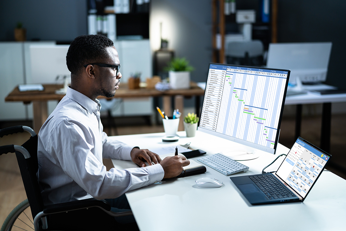 person in wheelchair doing work on a computer