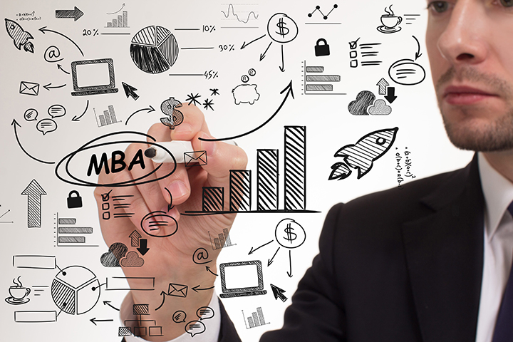 Young businessman thinks over the steps for successful growth of an MBA at a whiteboard.