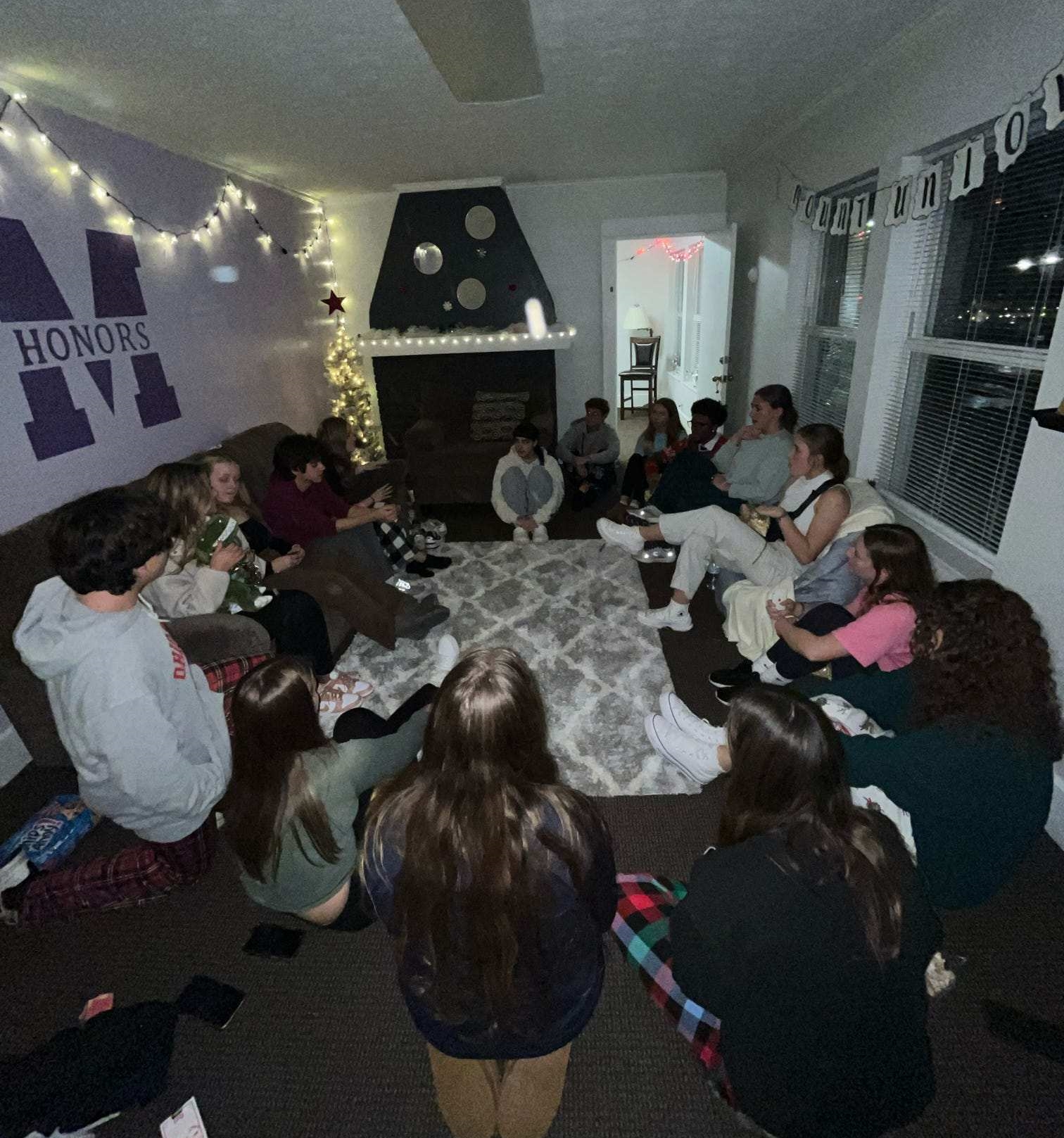 students sitting in circle inside of honors house