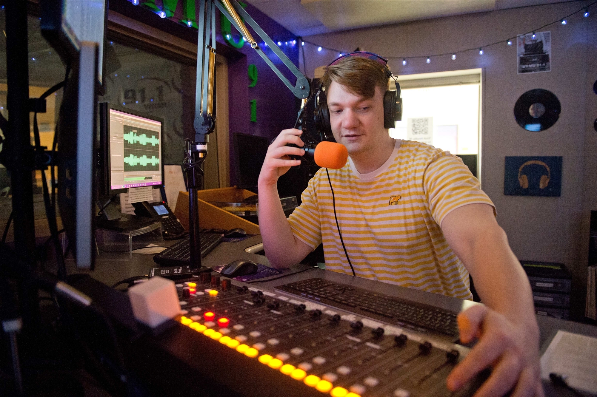 Media student working soundboard at 91.1 FM
