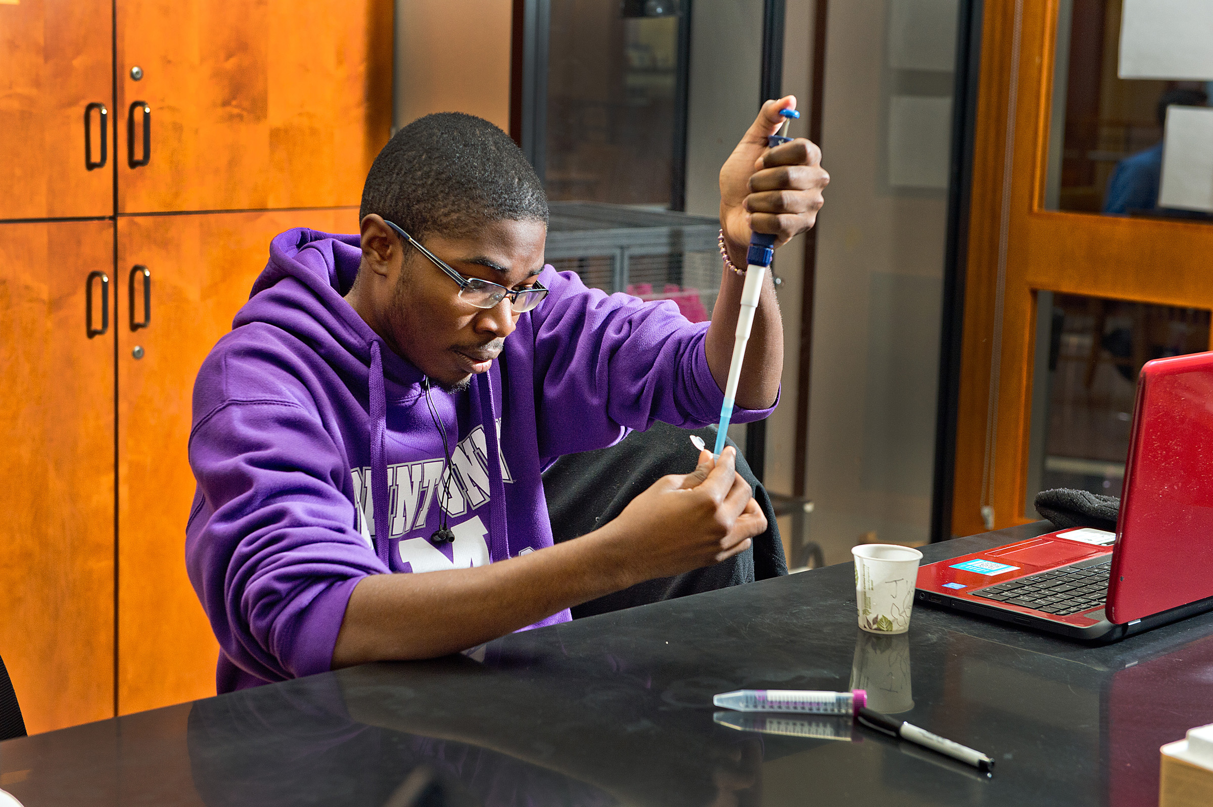 Biology student measures out a sample in a lab