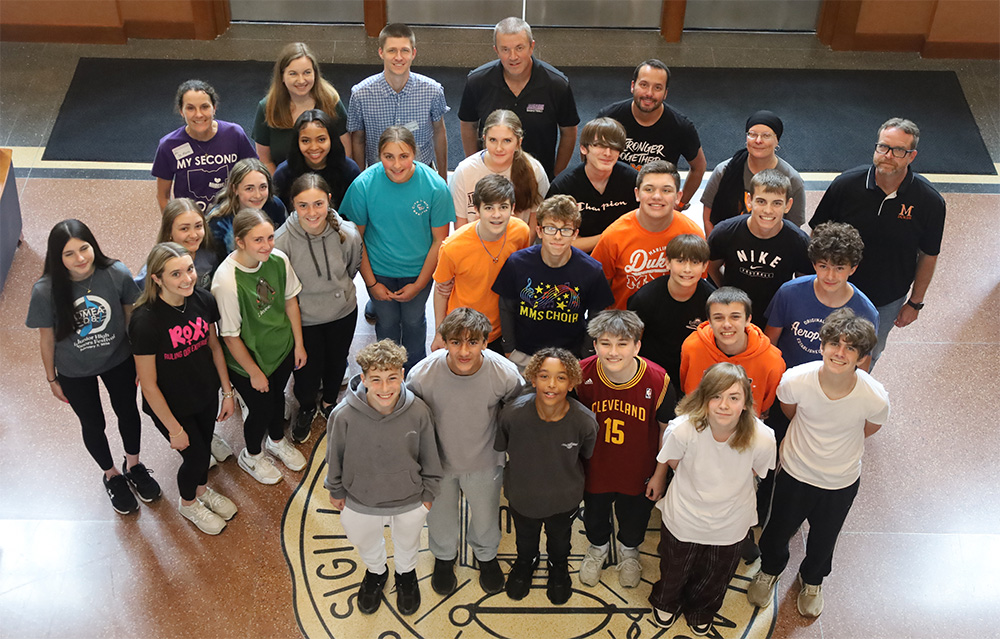 Group of middle school students posing with Mount Union faculty