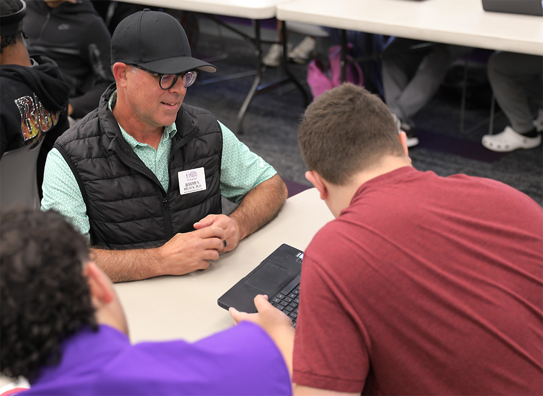 Faculty member talking with student while looking at computer