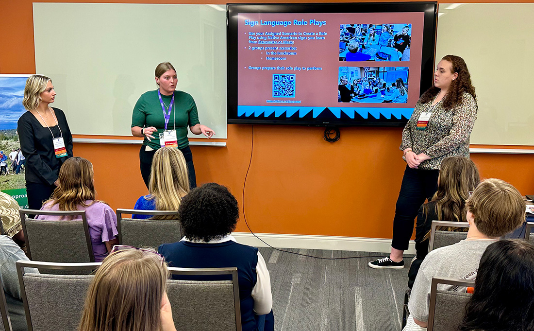 three students presenting at conference 