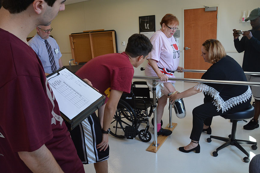 Engineering students and PT faculty member testing an adaptable prosthetic leg