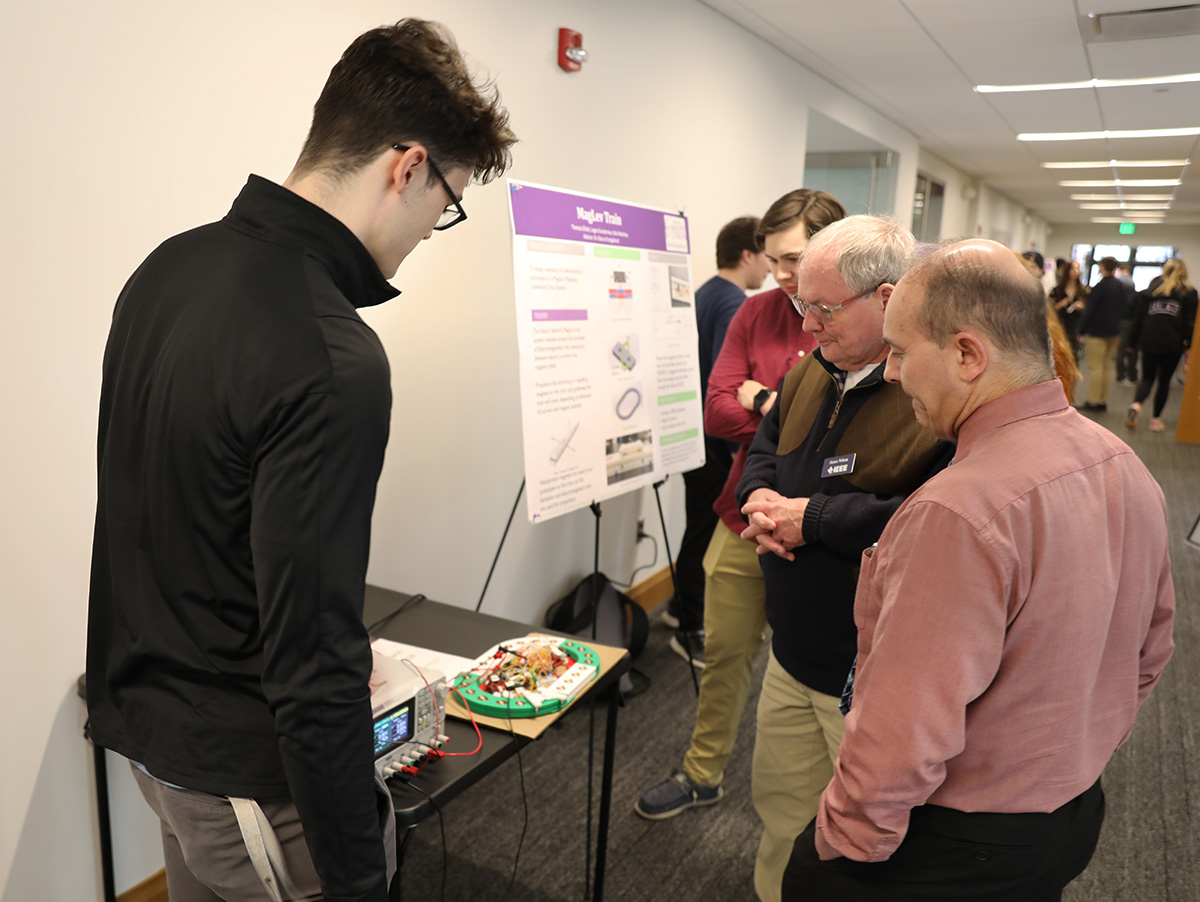 student presenting project to two community members