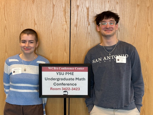 Two students posing with signage at the 2026 PME Conference 