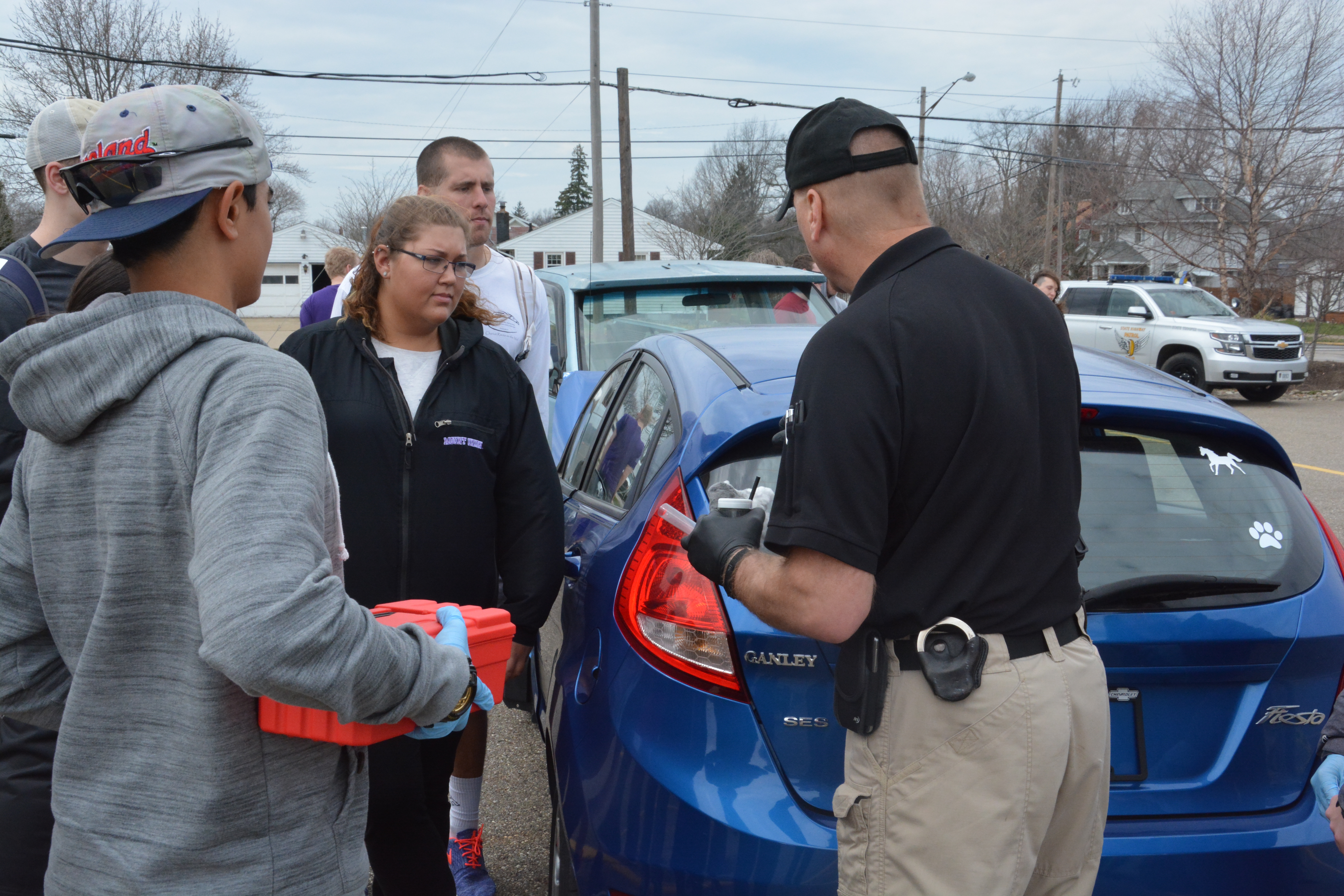 Students with a state highway patrolman at a mock crash scene