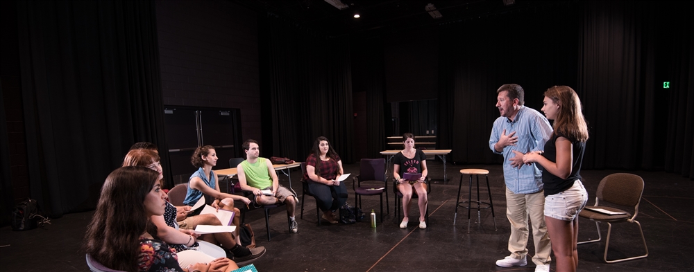 Professor teaching a group of students in a theater