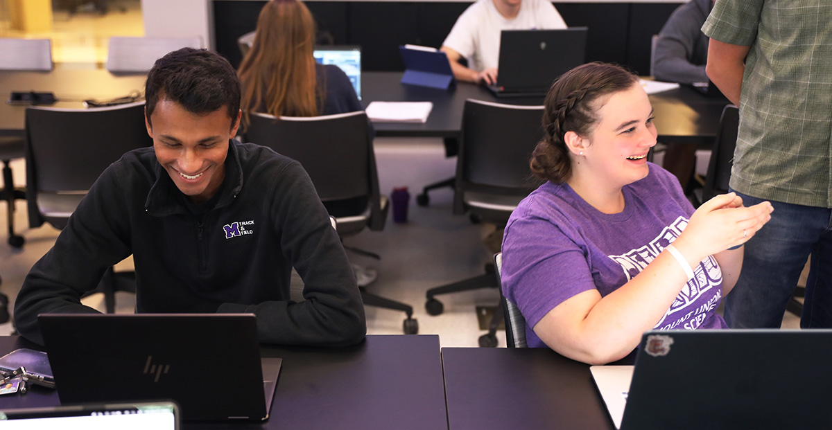 Two students in data science center laughing