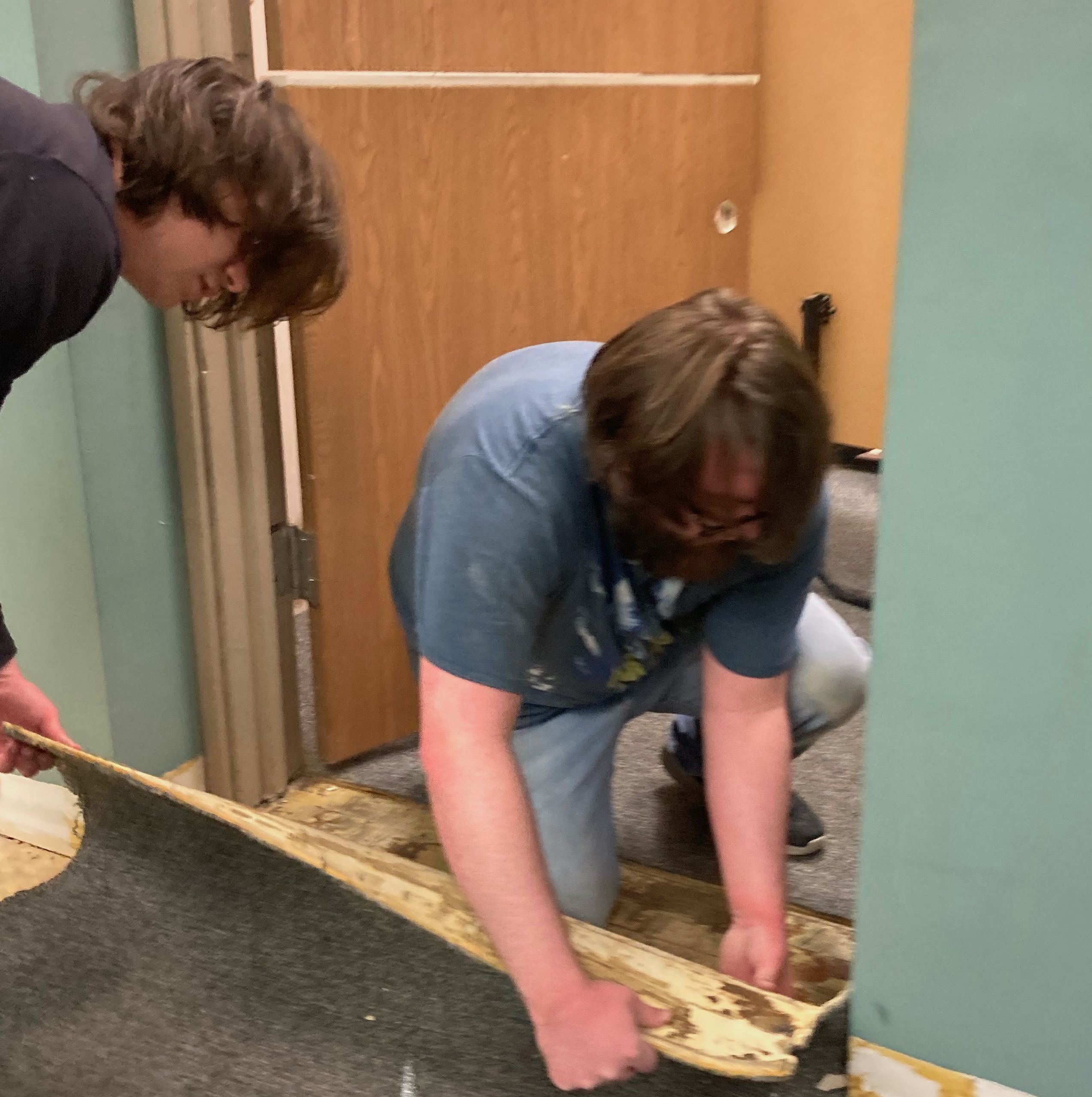 students tearing up carpet in hallway