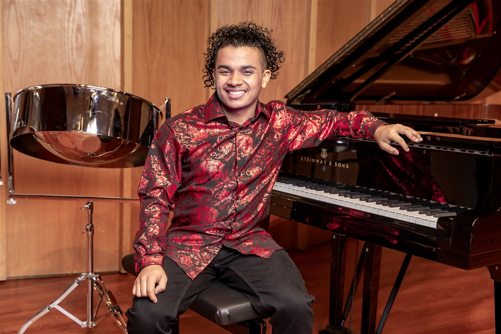 Jaden Teague-Nuñe in front of piano and steel pan drum
