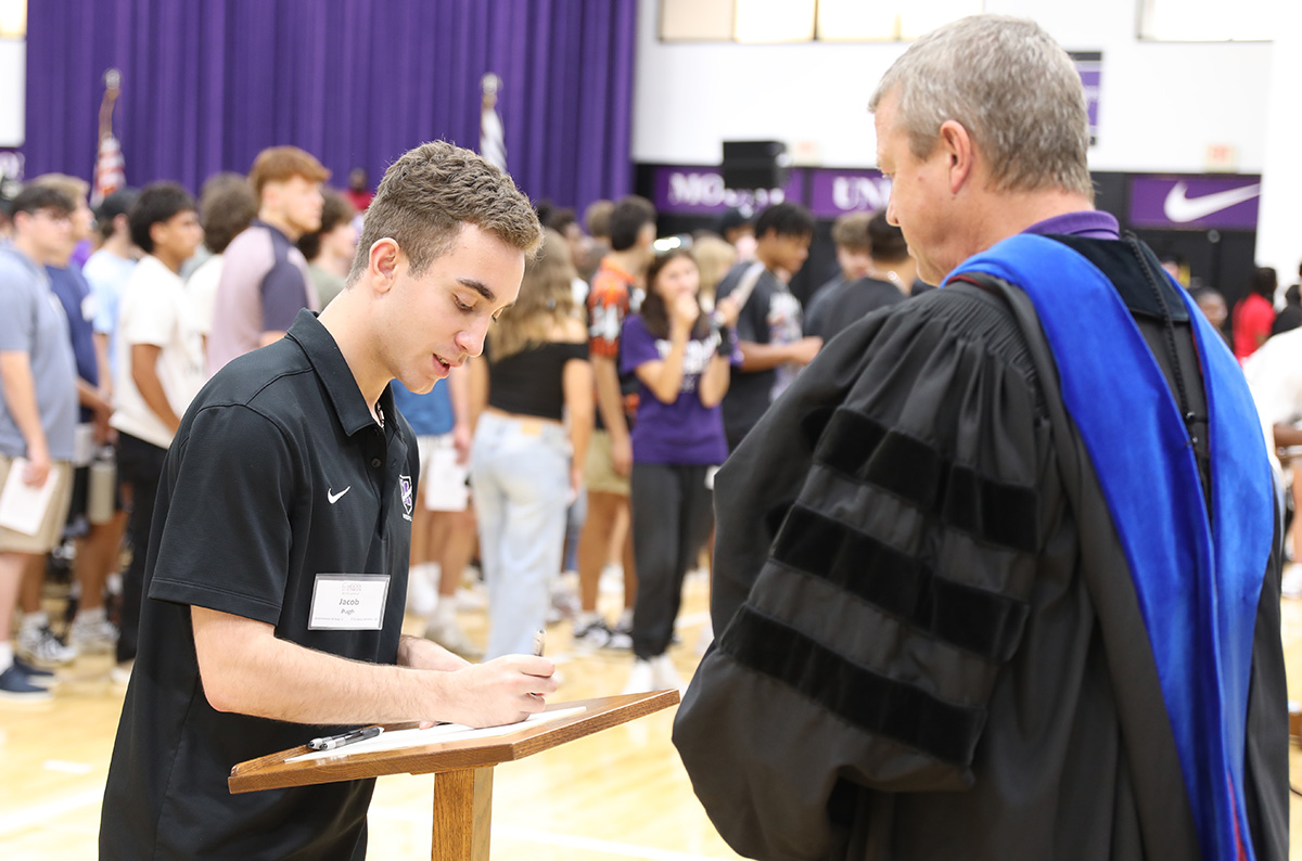 student signing book