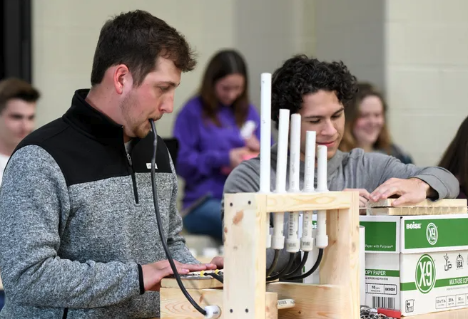 physics students playing homemade instruments