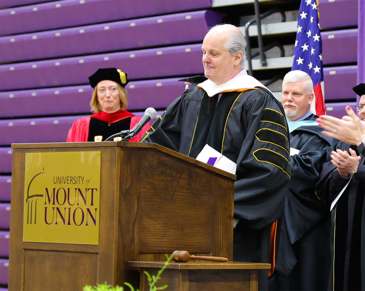 andrew price standing at podium smiling with eyes closed