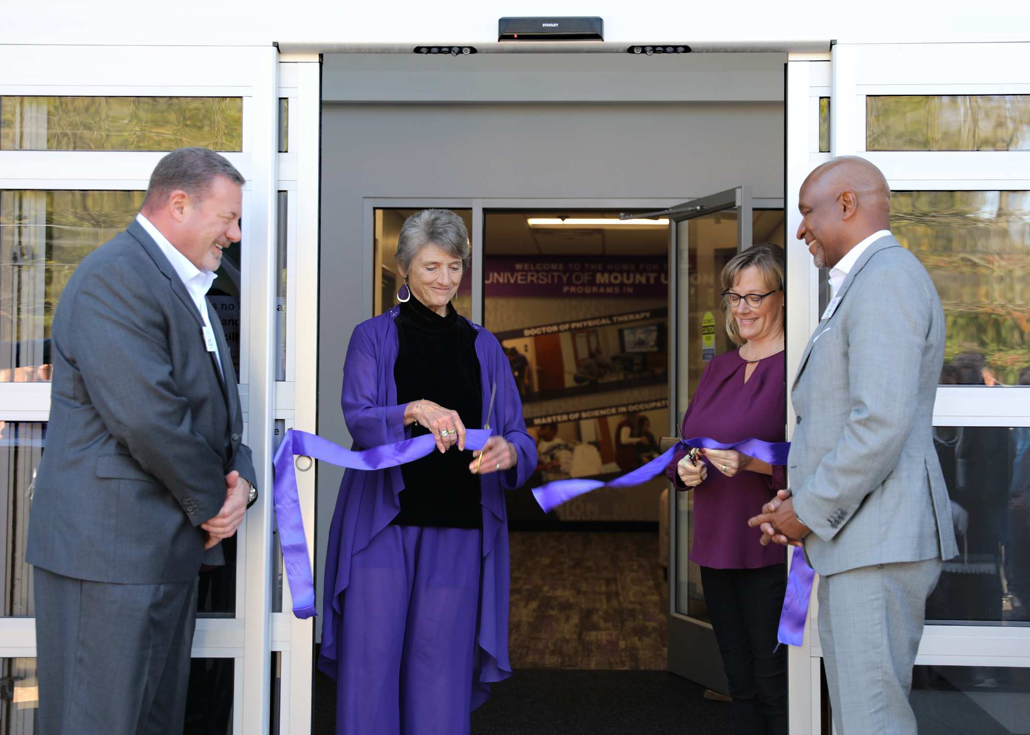 Faculty cutting ribbon at new facility event