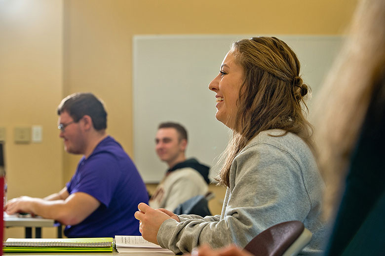 student in classroom smiling