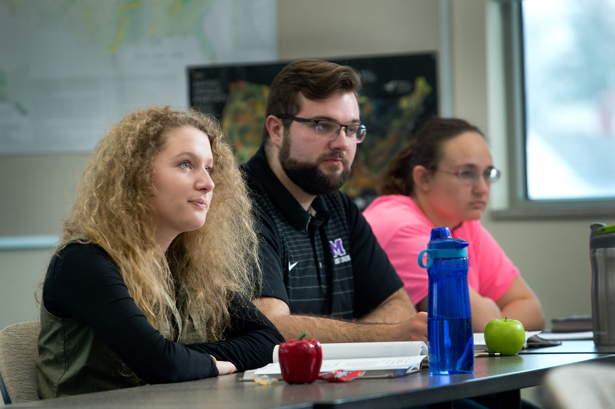 Students listening in class in front of a whiteboard