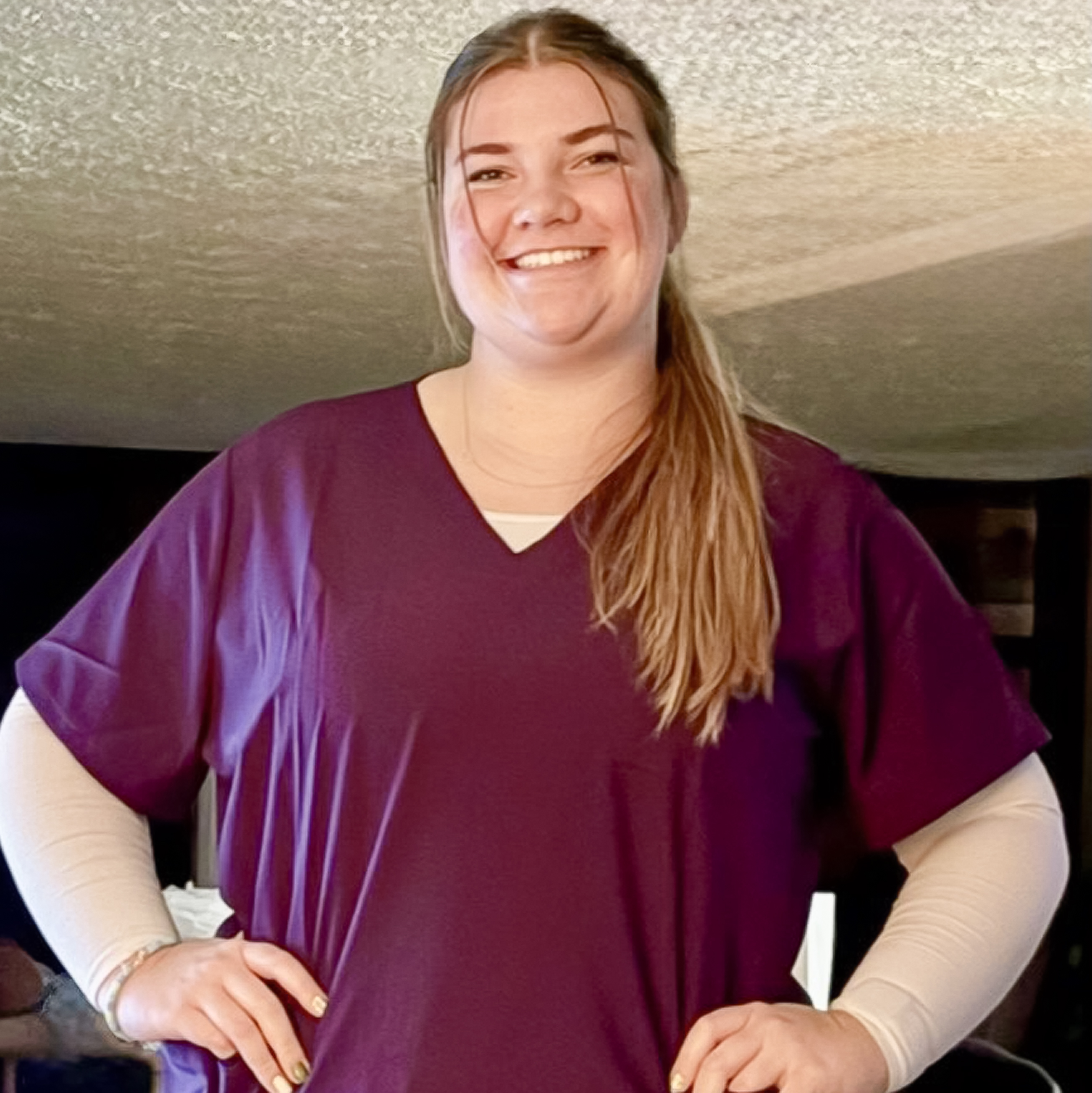 Austine Kinney M'27 posing for a photo in scrubs